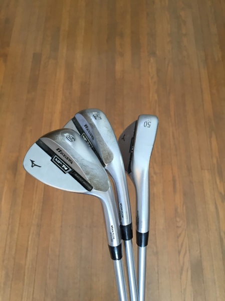 Wedges:  Mizuno MP-T4 50°, 55°, 60° Each of these wedges has a custom grind, allowing different amounts of bounce to be used for each wedge.  This allows me to play a variety of shots using the club with an open or closed face with confidence around the green.  I have my 54 degree wedge bent to 55 degrees to keep a consistent 5 degree gap between the wedges, eliminating the possibility of a large yardage gap. 